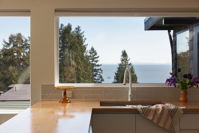 Staged kitchen sink with gooseneck faucet overlooking the ocean