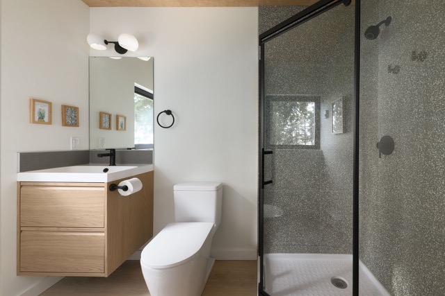 Main bathroom with floating oak vanity and textured glass shower